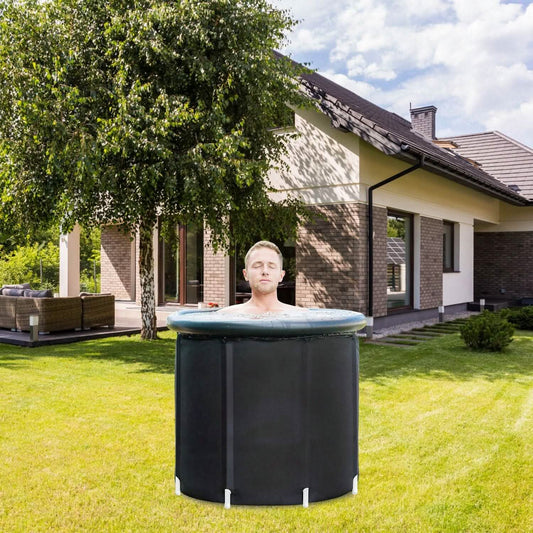 Person in a portable hot tub outdoors in front of a house