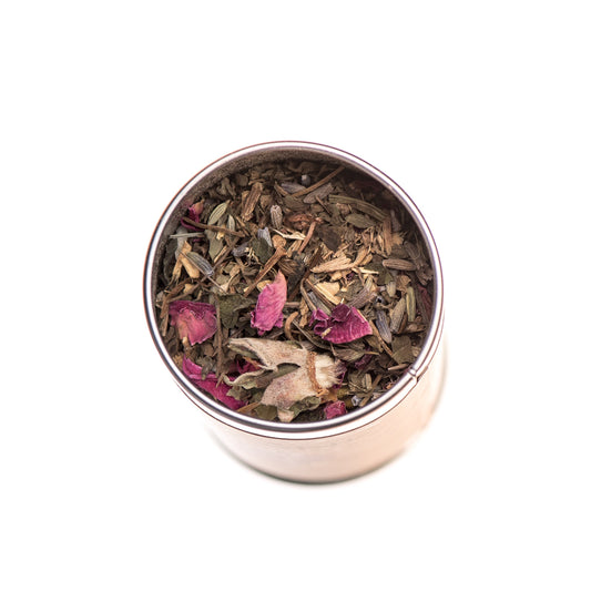 Tea leaves with pink petals in a metal container on a white background