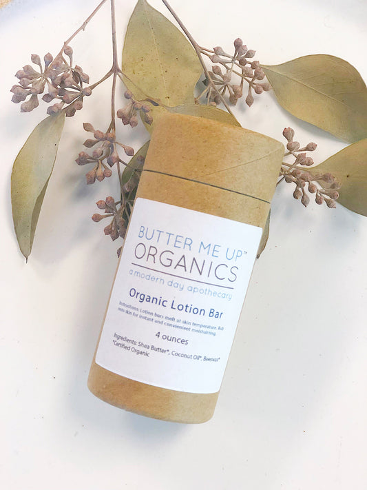 Butter Me Up Organics organic lotion bar with eucalyptus leaves on a white background