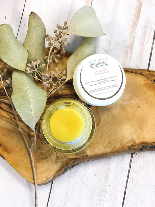 Scar Serum container opened on a wooden tray with florals