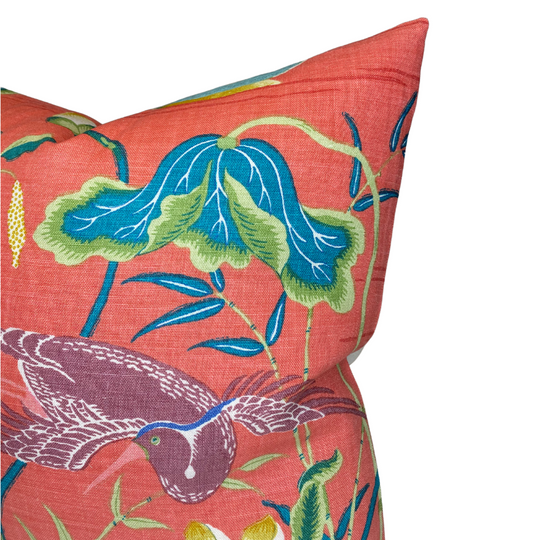 Decorative pillow with bird and leaf pattern on a red background