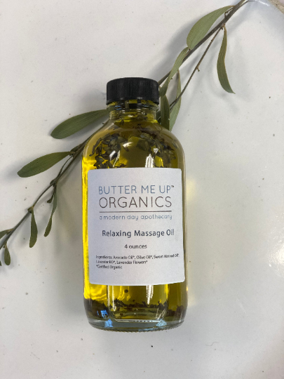 Bottle of Butter Me Up Organics relaxing massage oil with a label on a white background.