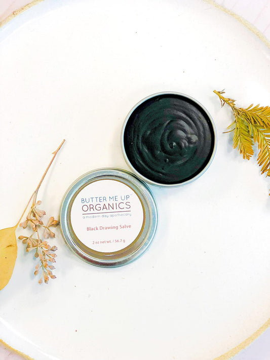 Black Drawing Salve opened container on white background