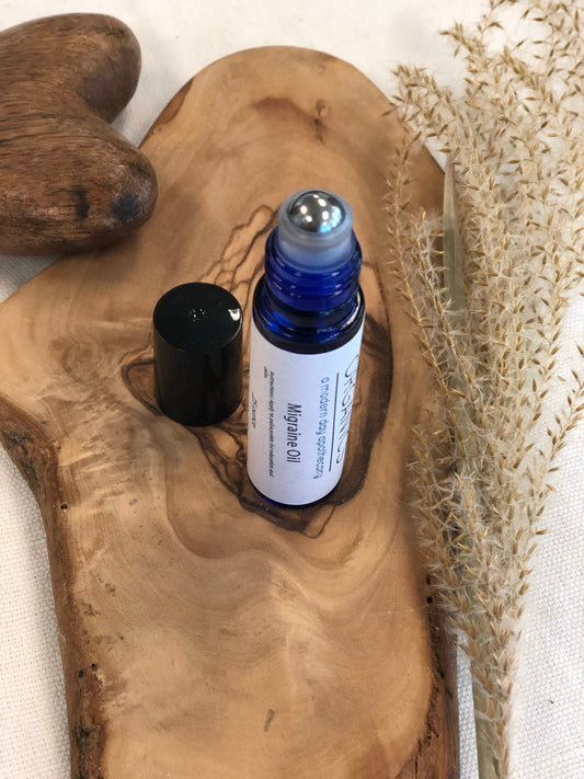 Two essential oil bottles on a wooden surface with dried plants.