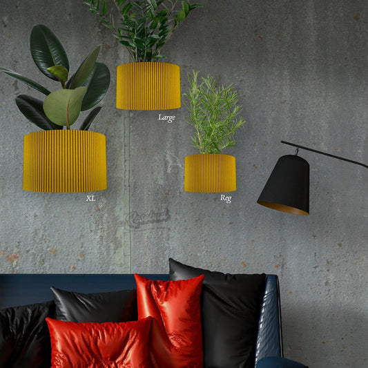 Yellow wall planters of different sizes on a gray wall with a black lamp and red cushions on a sofa.