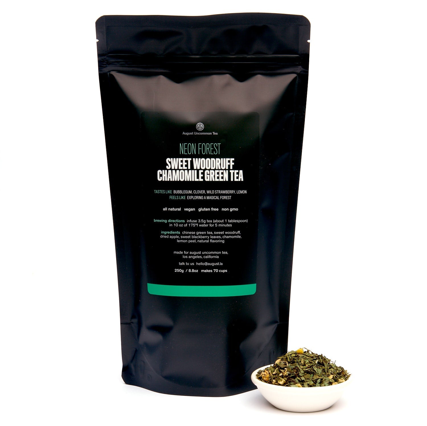 Black tea packaging with green text and a small bowl of tea leaves on a white background