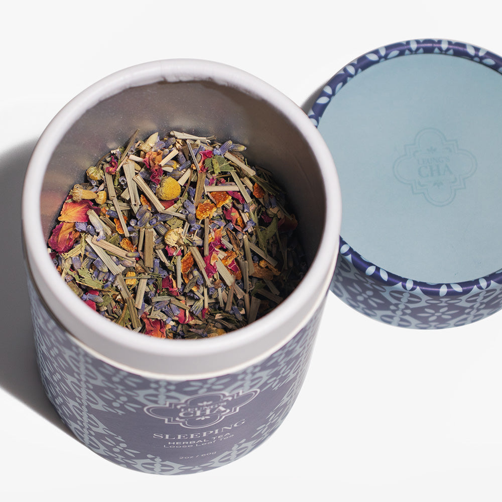 Tea canister with colorful tea leaves and decorative lid on a white background