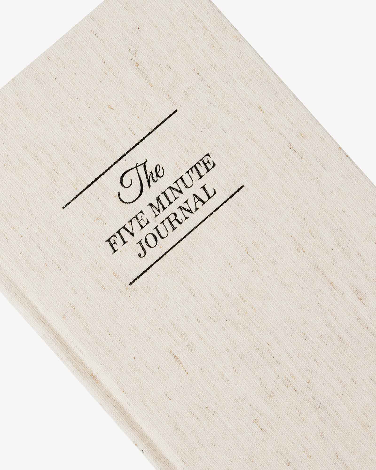 Beige journal with 'The Five Minute Journal' text on a white background