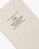 Beige journal with 'The Five Minute Journal' text on a white background