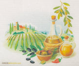 Decorative towel with olive oil bottle, bowl of olives, and landscape design.