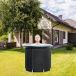Person in a portable hot tub outdoors in front of a house