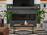 Modern living room with a fireplace, plants, and a coffee table.