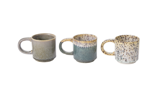 Three ceramic mugs with speckled patterns on a white background
