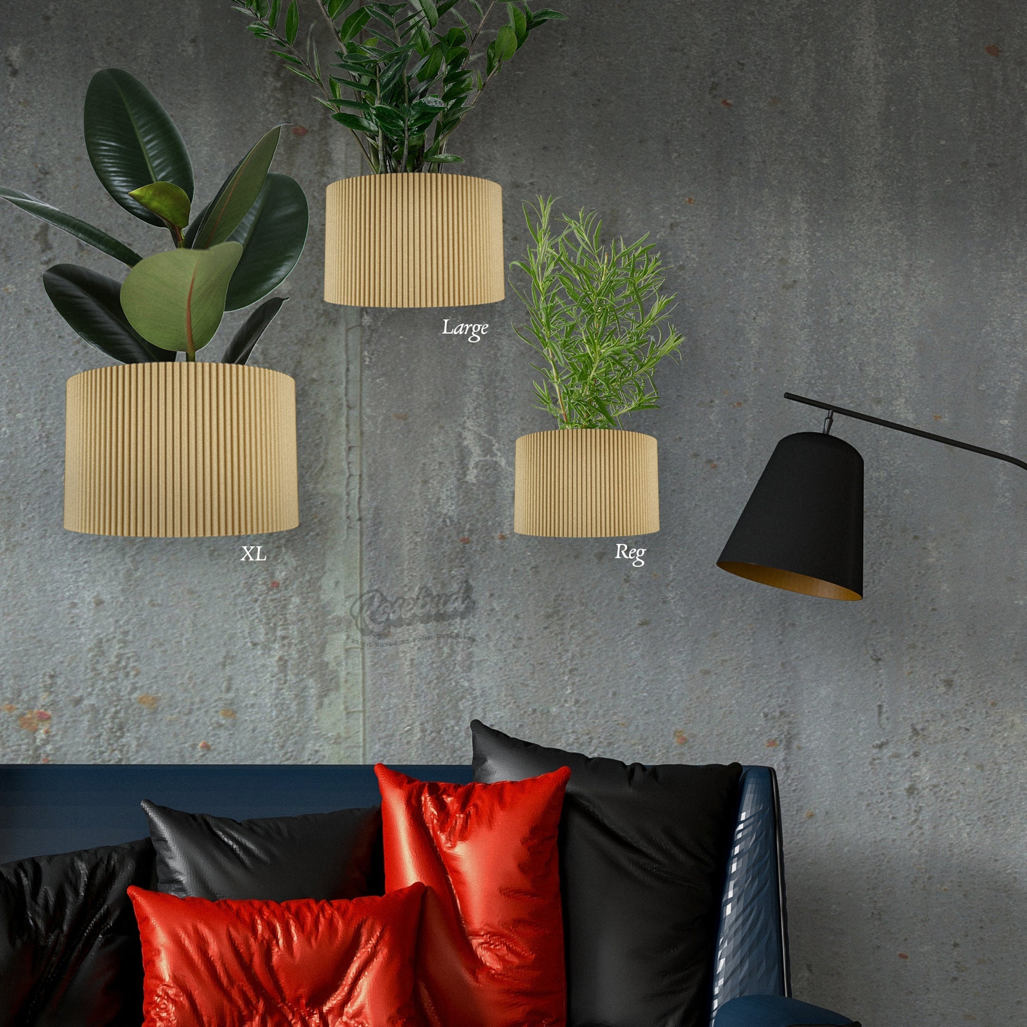 Three decorative planters with plants on a gray wall above a sofa with colorful pillows.